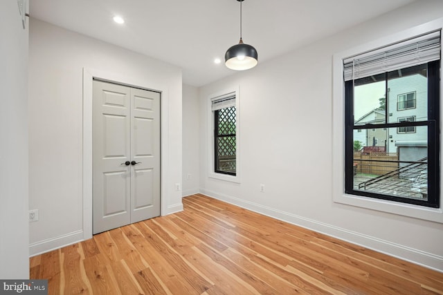 unfurnished bedroom with light hardwood / wood-style flooring and a closet