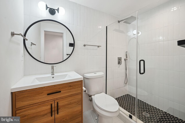 bathroom with vanity, decorative backsplash, tile walls, toilet, and walk in shower