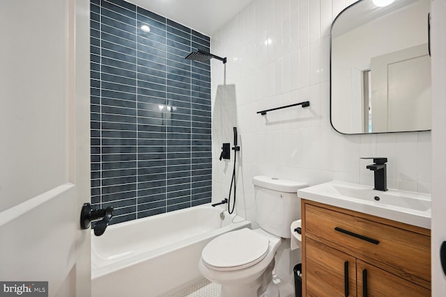 full bathroom featuring tile walls, tiled shower / bath combo, toilet, vanity, and decorative backsplash