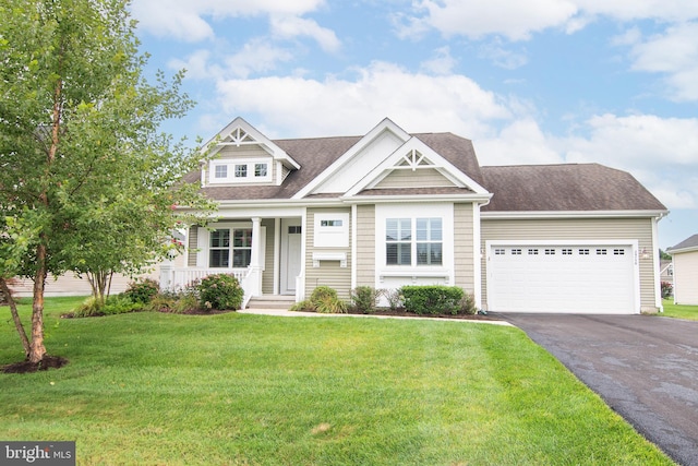 view of front of house featuring a garage, covered porch, and a front yard