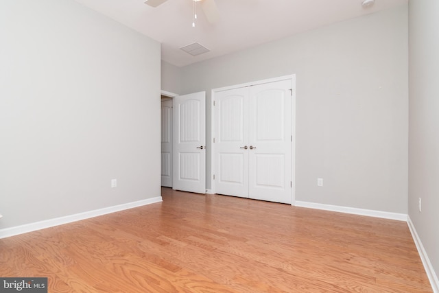 unfurnished bedroom with light hardwood / wood-style flooring, a closet, and ceiling fan