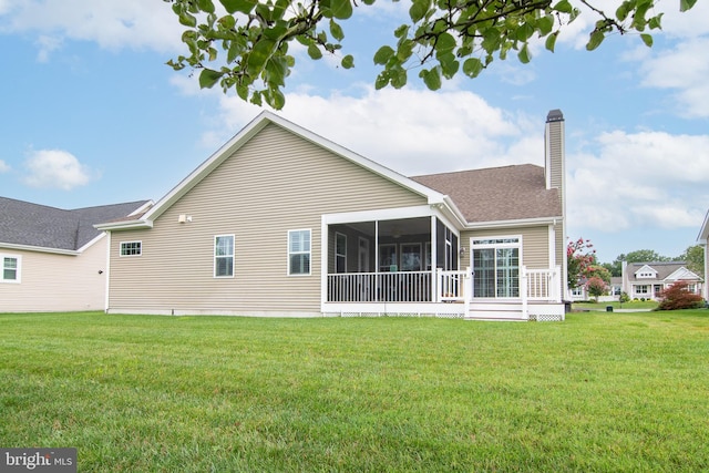 back of property with a lawn and a sunroom