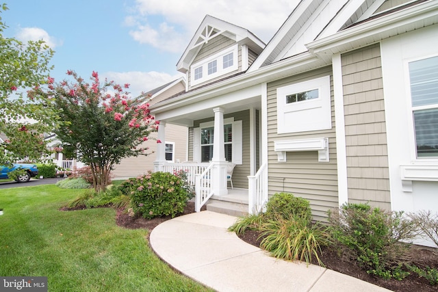 exterior space featuring covered porch and a front yard