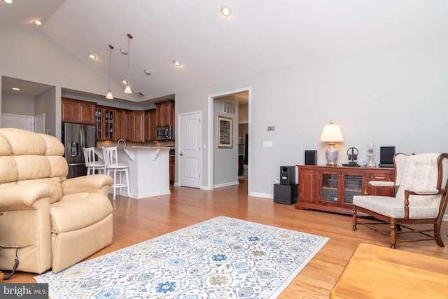 living room featuring light hardwood / wood-style flooring and high vaulted ceiling