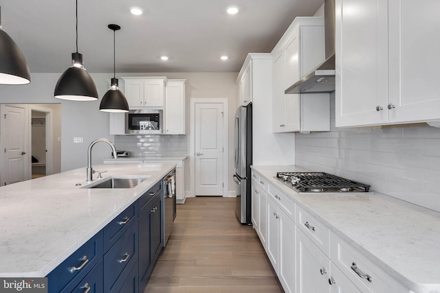 kitchen with white cabinetry, appliances with stainless steel finishes, blue cabinetry, and pendant lighting