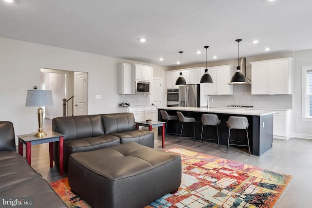 living room featuring sink and light hardwood / wood-style floors