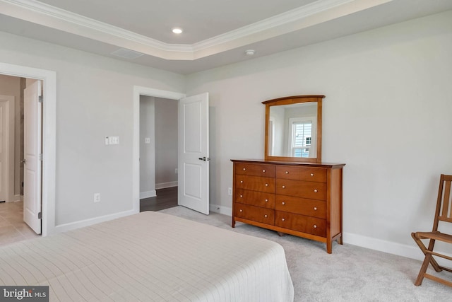 bedroom with a raised ceiling, crown molding, and light carpet