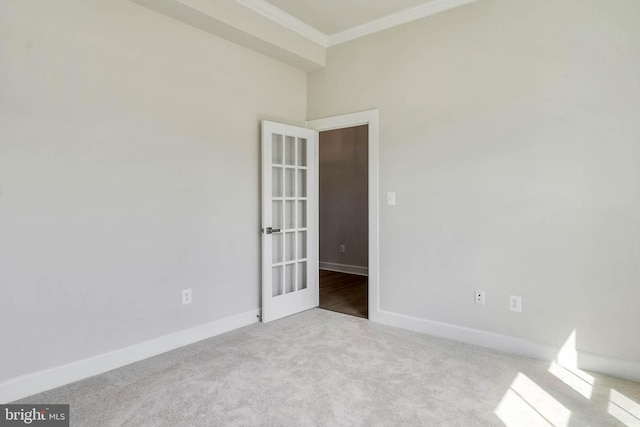 carpeted spare room with ornamental molding and french doors