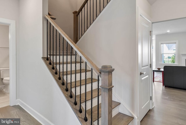 staircase with hardwood / wood-style flooring