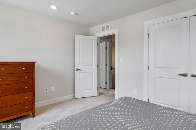 unfurnished bedroom with light colored carpet and a closet