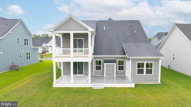 back of property with cooling unit, a lawn, and a balcony