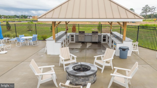 view of patio featuring a gazebo, area for grilling, and a fire pit