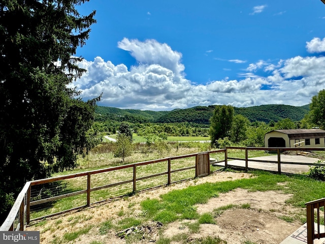 view of yard with a rural view and a mountain view