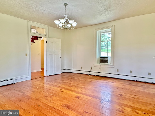 interior space with a textured ceiling, an inviting chandelier, cooling unit, a baseboard heating unit, and light wood-type flooring