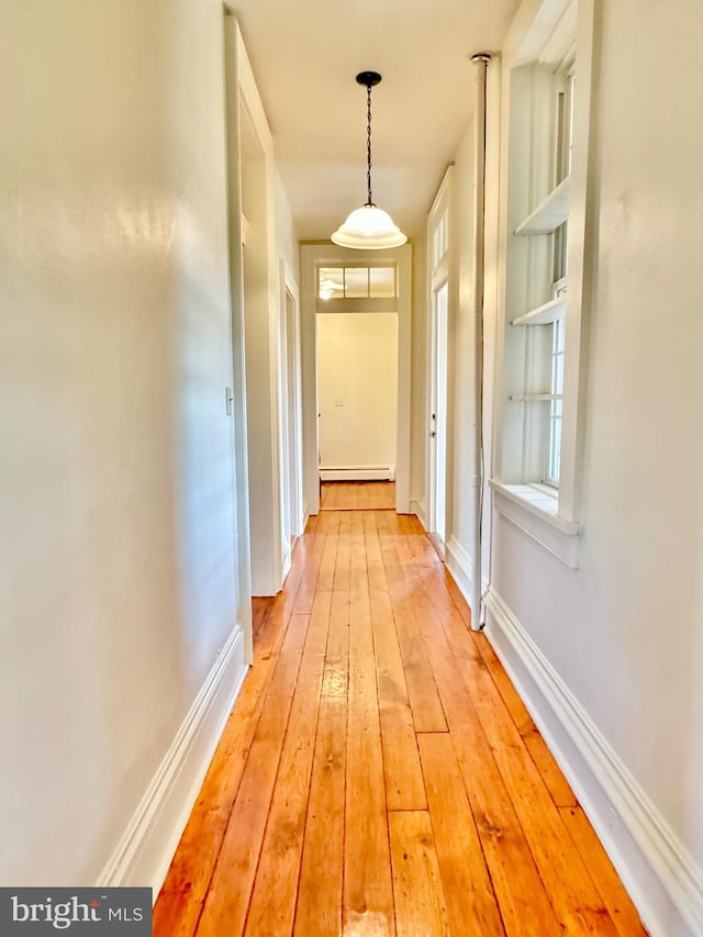 entryway with a healthy amount of sunlight, baseboard heating, and light hardwood / wood-style floors