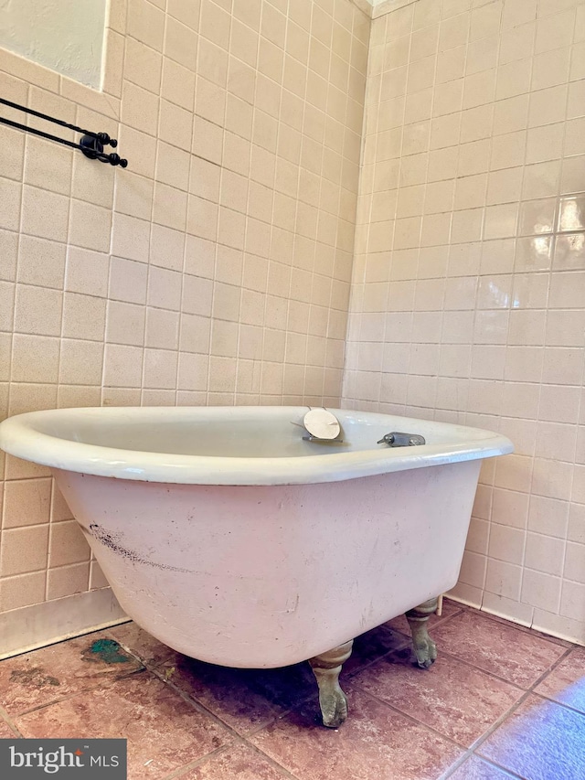 bathroom with a tub and tile walls