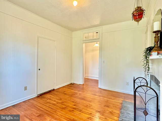 unfurnished bedroom featuring a textured ceiling and light hardwood / wood-style floors