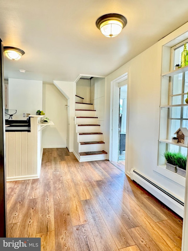 interior space featuring light wood-type flooring and baseboard heating