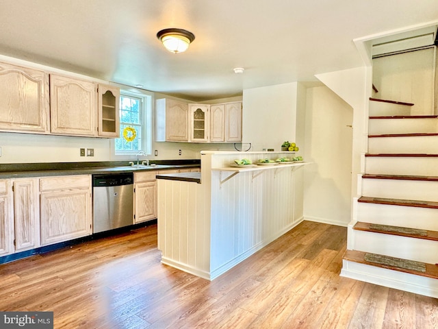 kitchen with dishwasher, sink, kitchen peninsula, and light hardwood / wood-style flooring