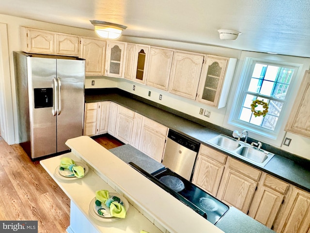 kitchen featuring light brown cabinetry, stainless steel appliances, sink, and light hardwood / wood-style floors