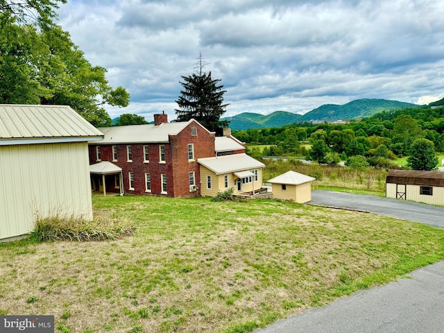 view of yard featuring a mountain view and a storage unit