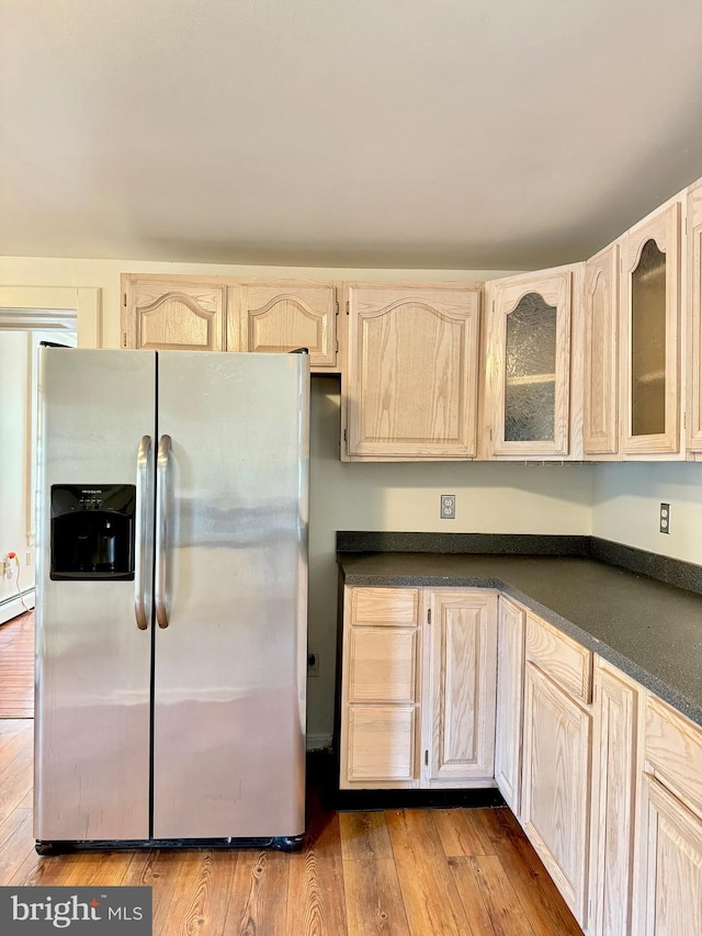 kitchen with light wood-type flooring, stainless steel fridge, and light brown cabinets