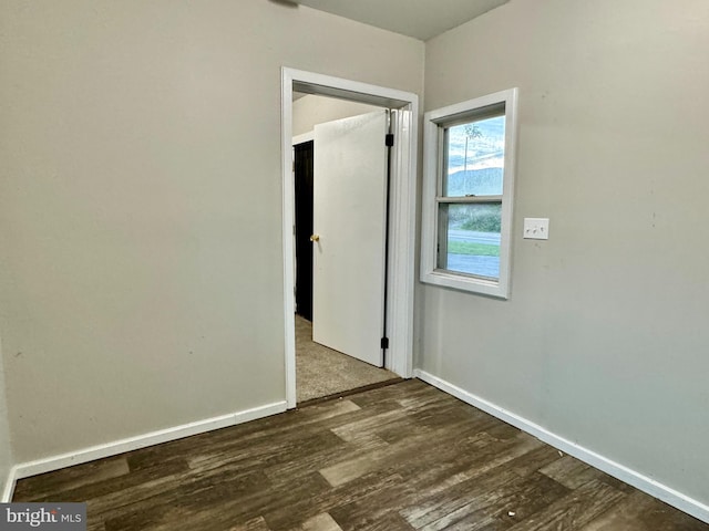 unfurnished room with baseboards and wood finished floors