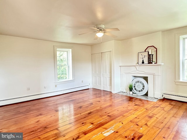 unfurnished living room featuring a baseboard radiator, ceiling fan, and light hardwood / wood-style floors