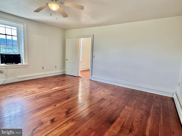 unfurnished room with hardwood / wood-style floors, cooling unit, and ceiling fan