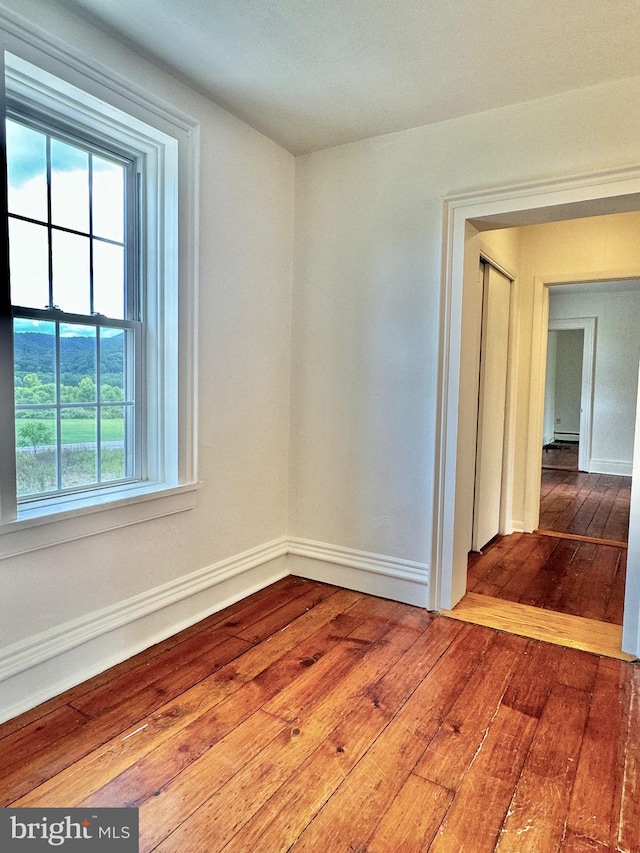 unfurnished room featuring hardwood / wood-style flooring and a wealth of natural light