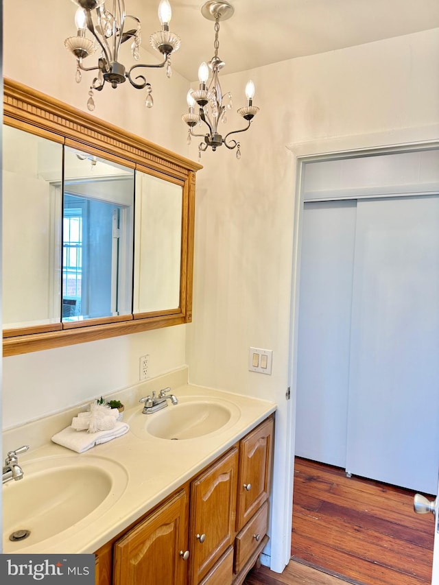 bathroom with vanity, wood-type flooring, and a notable chandelier