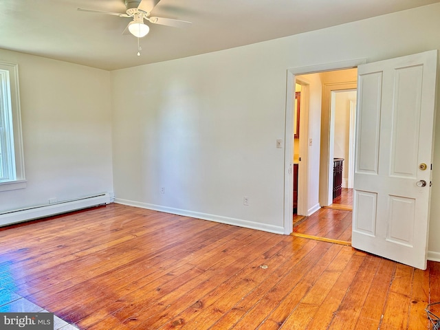 empty room featuring a baseboard heating unit, ceiling fan, and light hardwood / wood-style flooring