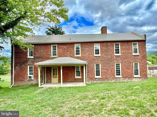 back of house featuring a lawn and a patio area