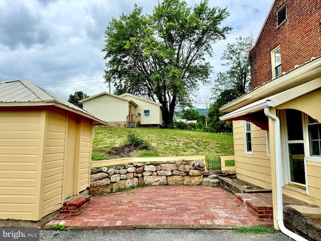 view of yard featuring a patio area and a storage unit