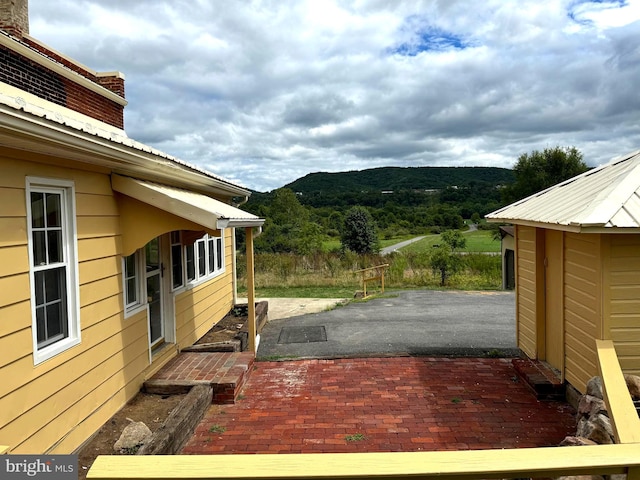 wooden deck with a mountain view and a patio area