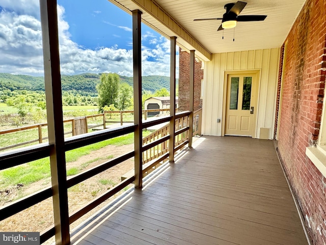 unfurnished sunroom with a wealth of natural light and ceiling fan