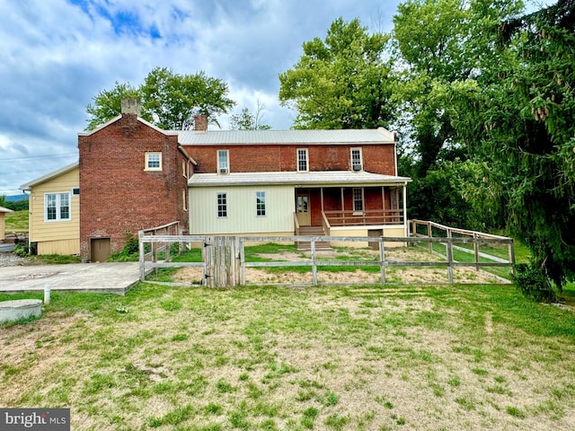 view of front facade featuring a chimney, metal roof, and brick siding