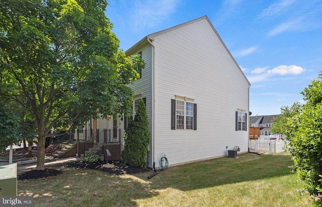 view of property exterior with central AC and a lawn