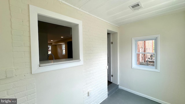 hallway with brick wall and sink