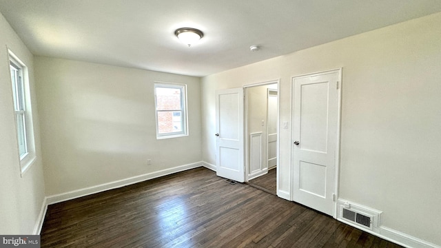 unfurnished bedroom featuring dark wood-type flooring and a closet