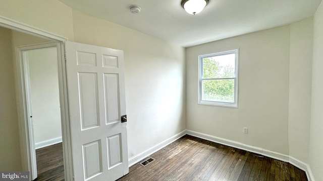 unfurnished room with dark hardwood / wood-style flooring