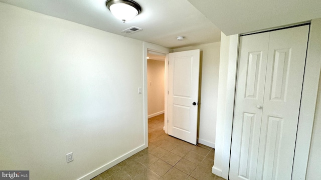 unfurnished bedroom featuring light tile patterned floors and a closet