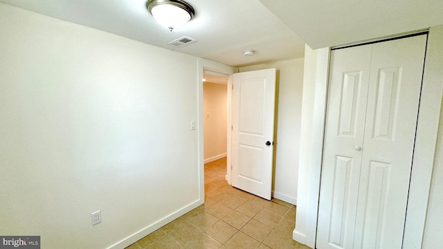 unfurnished bedroom featuring light tile patterned floors and a closet