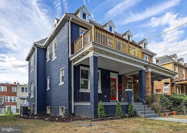 view of front facade with a balcony, central AC unit, and a porch