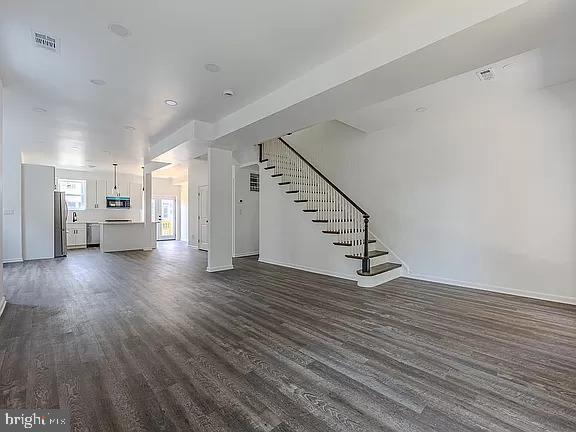 unfurnished living room with dark hardwood / wood-style floors