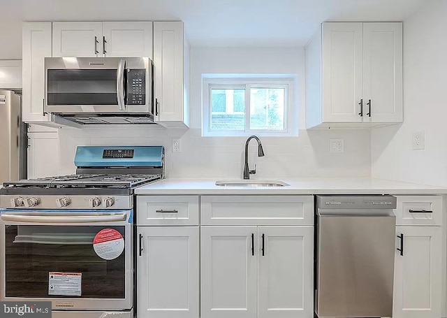 kitchen featuring appliances with stainless steel finishes, sink, and white cabinetry