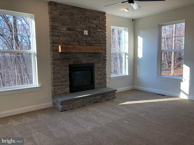 unfurnished living room with a fireplace, carpet floors, and ceiling fan