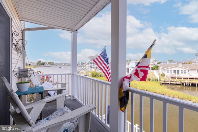 balcony with a water view and a boat dock