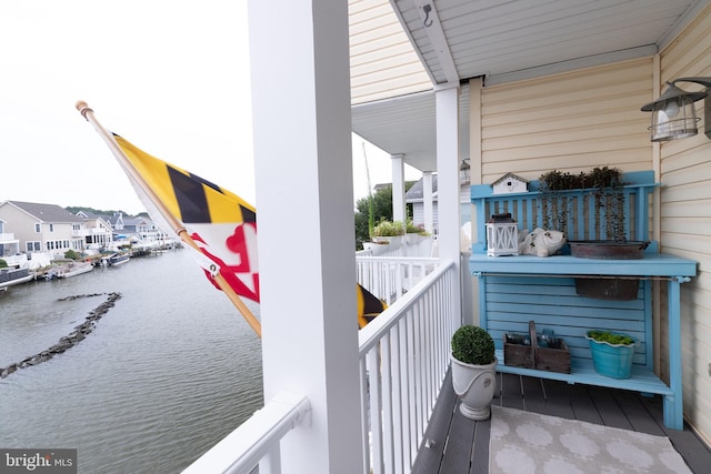 balcony with covered porch and a water view