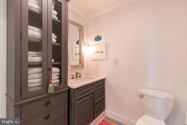 bathroom featuring tile walls, crown molding, vanity, and toilet